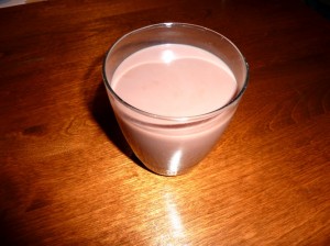 A glass of soy milk sitting on a table 