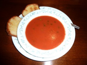 A bowl of tomato soup with toast
